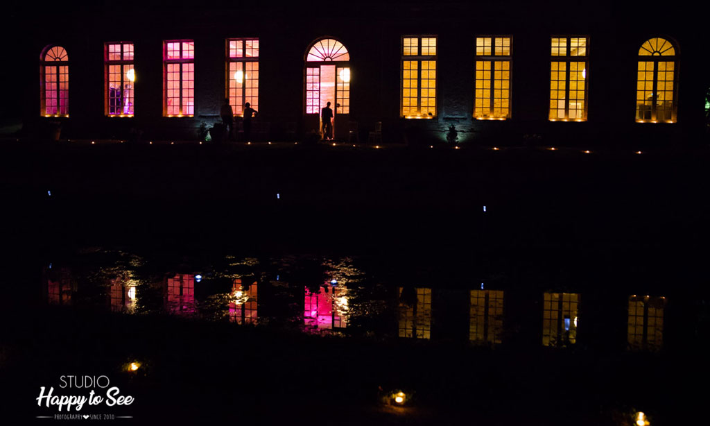 Orangerie vue de nuit avec des lumières colorées par les fenêtres
